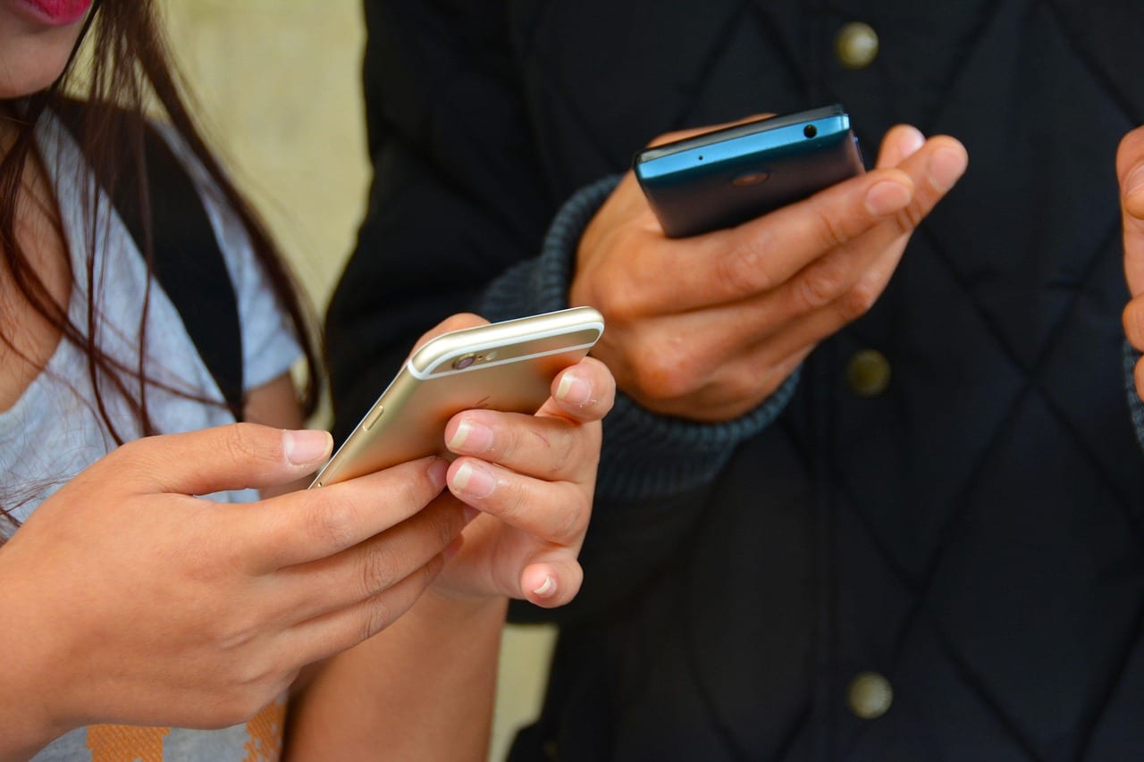 Mani che scrivono un messaggio sullo smartphone per chiedere la demo del sito web